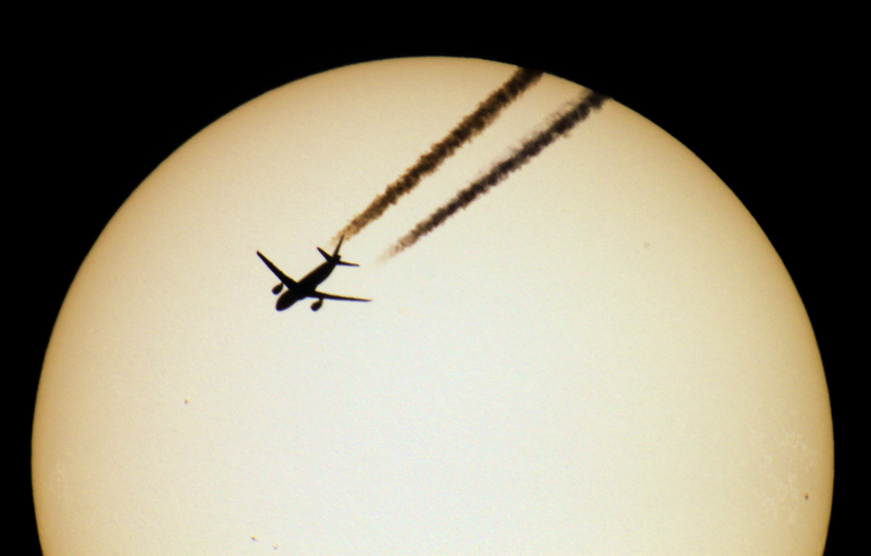 Illustration for article titled Perfectly Timed Pics of Airplanes Silhouetted Against the Sun and Moon